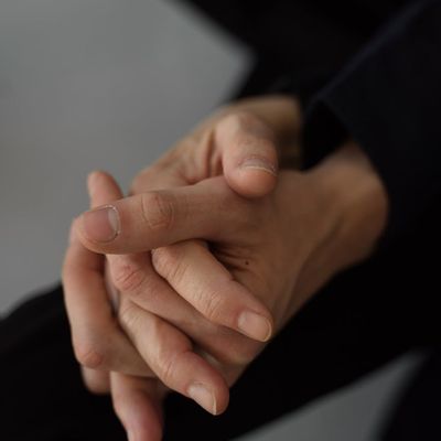 Hands folded together in a gesture of gentle warmth.