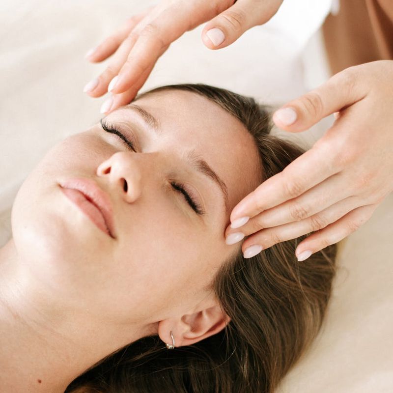 Serene face in profile with eyes closed in sunlight.